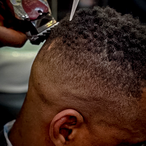 Barber shaping a precise skin fade with clippers